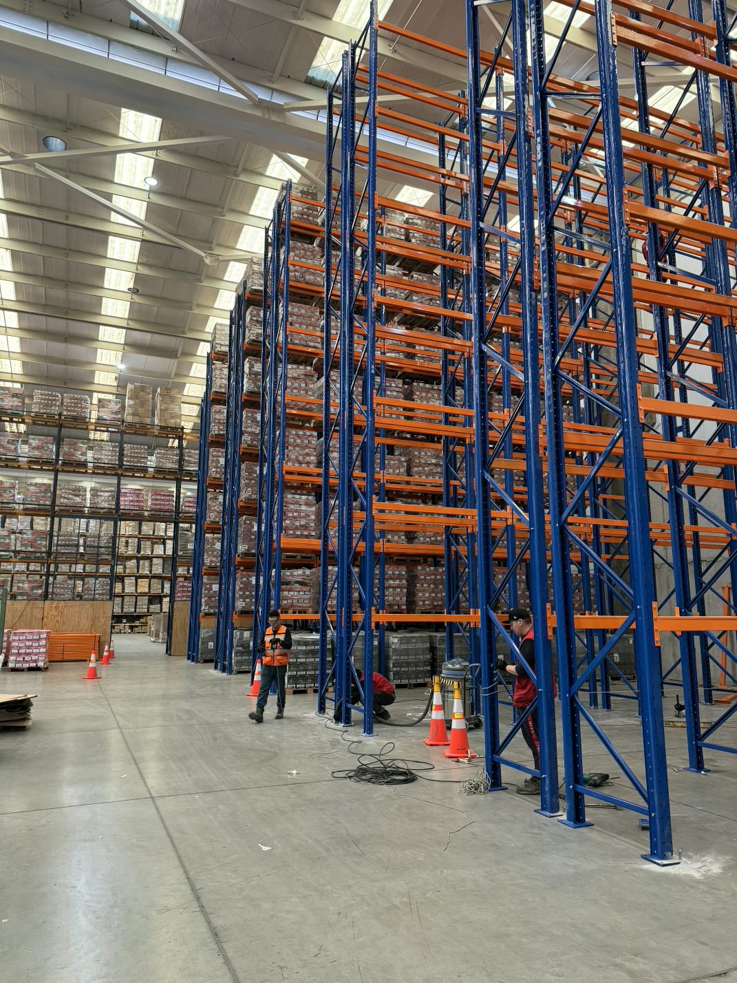 Interior de centro logístico con estructura metálica y pallets en almacenamiento